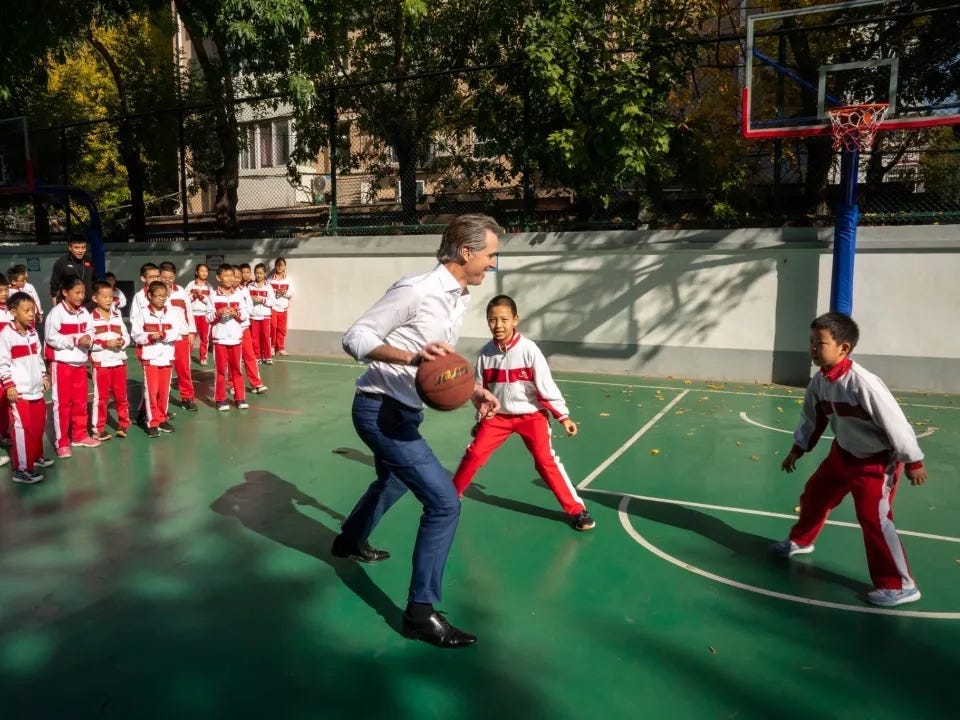 Watch Gavin Newsom accidentally tackle a kid while playing basketball in China