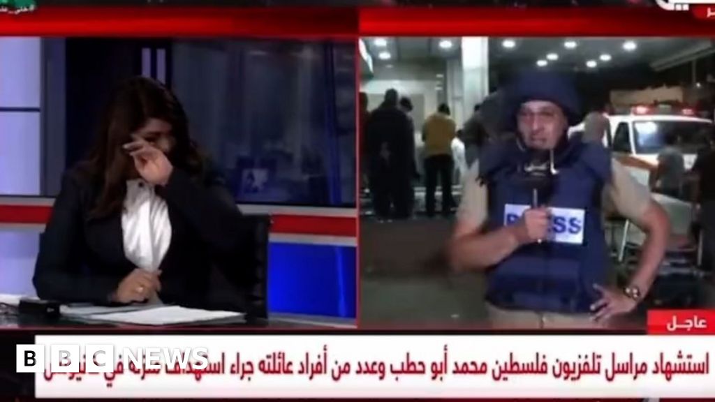 Gaza reporter removes protective vest after learning of colleague's death on air
