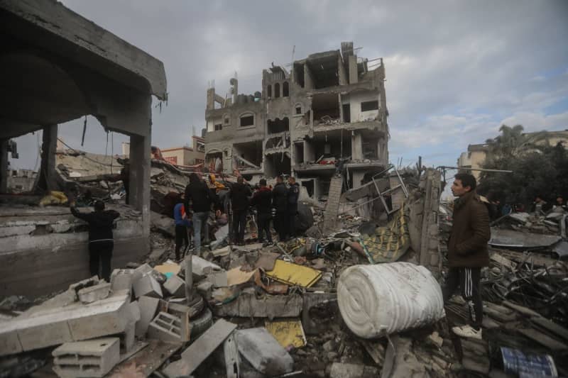 Palestinians inspect the rubble of destroyed buildings after heavy Israeli bombardment of the Al-Maghazi camp in the central Gaza Strip. The Hamas-controlled Ministry of Health said more than 70 people were killed. Mohammed Talatene/dpa