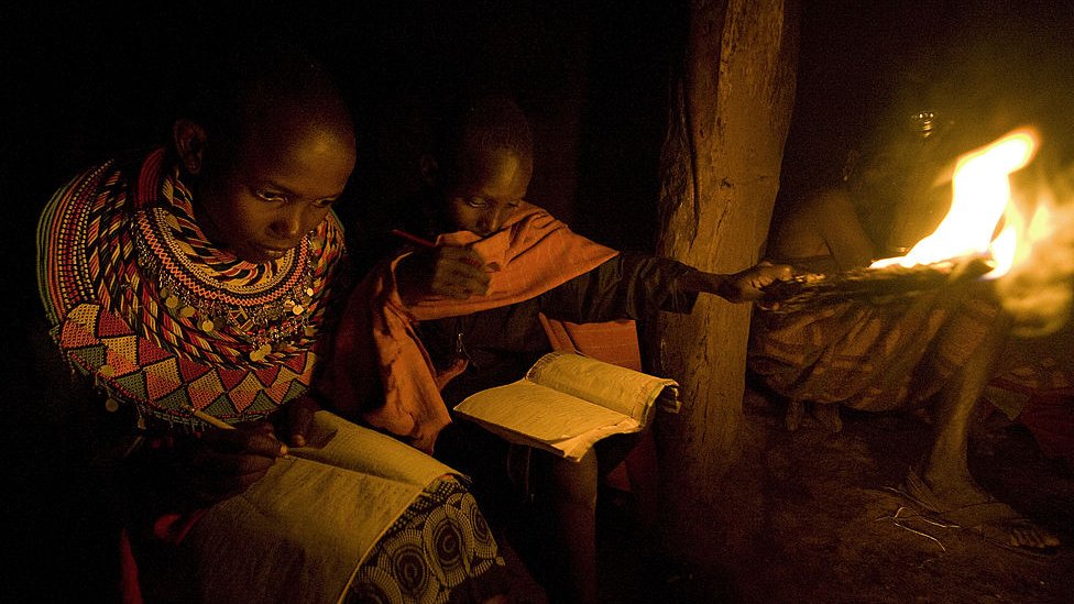 Photo taken on May 24, 2012 shows children studying at night using a flame on a stick in their manyatta [mud-thatch home] at Kisima in Samburu county, approximately 350 kilometres north of Nairobi.