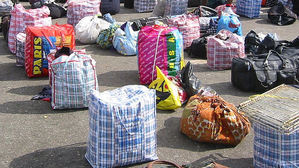 Nigerian returnees and Liberian refugees from war-torn Liberia identify their luggage 20 June, 2003 at the Lagos camp of the National Youth Service Corps.